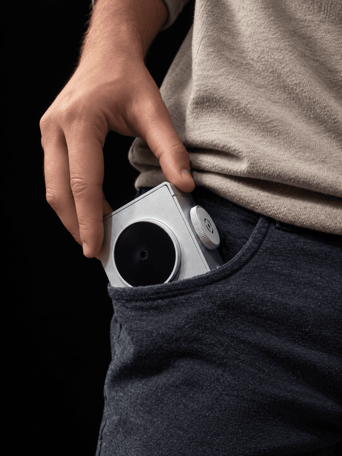 Silver Sticker Camera slipping into a jeans pocket